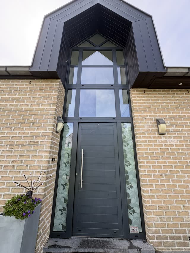 Porte d'entrée de maison avec imposte vitrée en hauteur, nettoyée à la perche